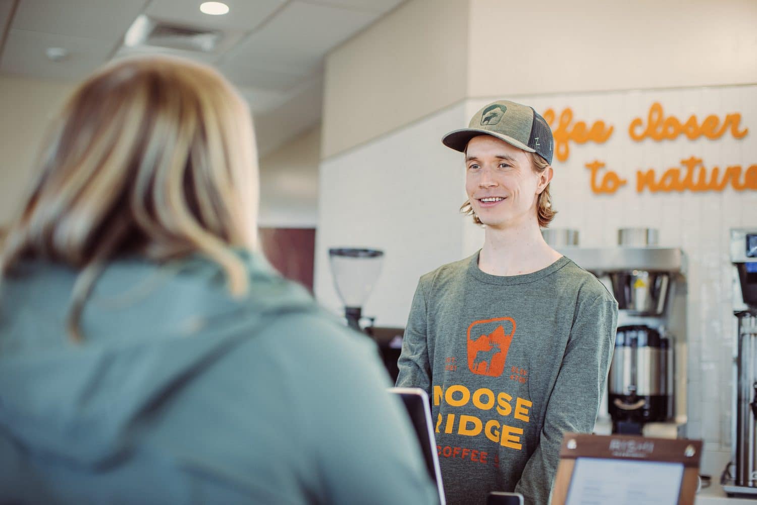 A barista chatting with a customer at the counter